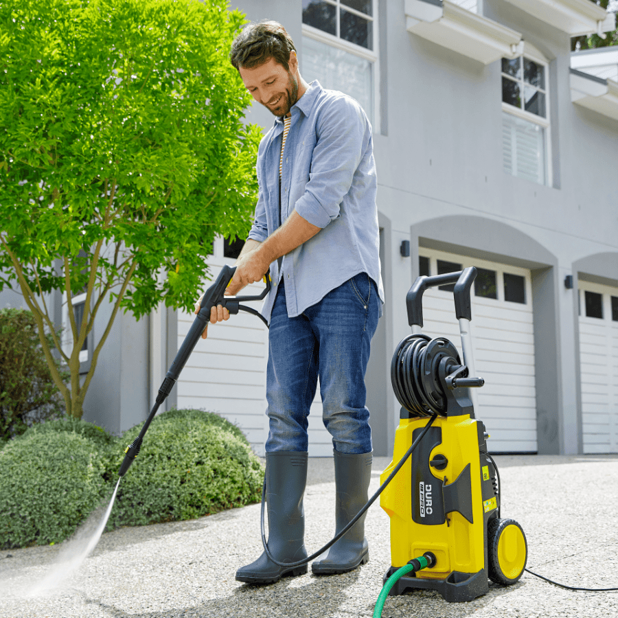 Hombre utilizando el artículo de Aldi para limpiar el jardín