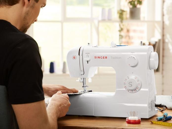 Hombre cosiendo con la máquina Singer de Lidl