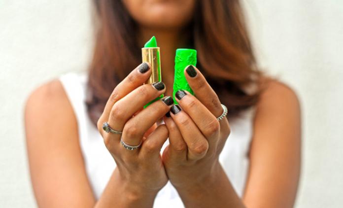Mujer sosteniendo el pintalabios verde