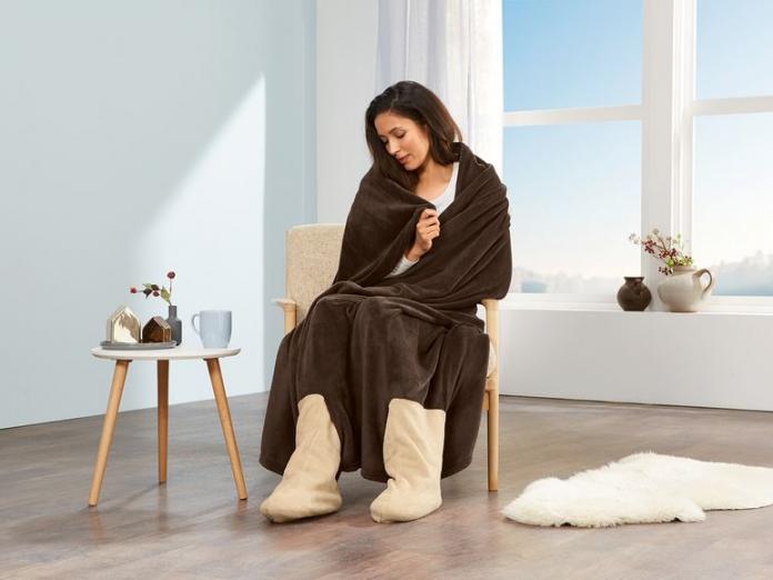 Mujer arropada con la manta con calcetines de Lidl