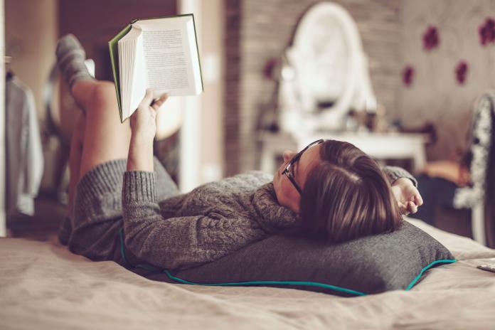 Mujer en la cama leyendo un libro