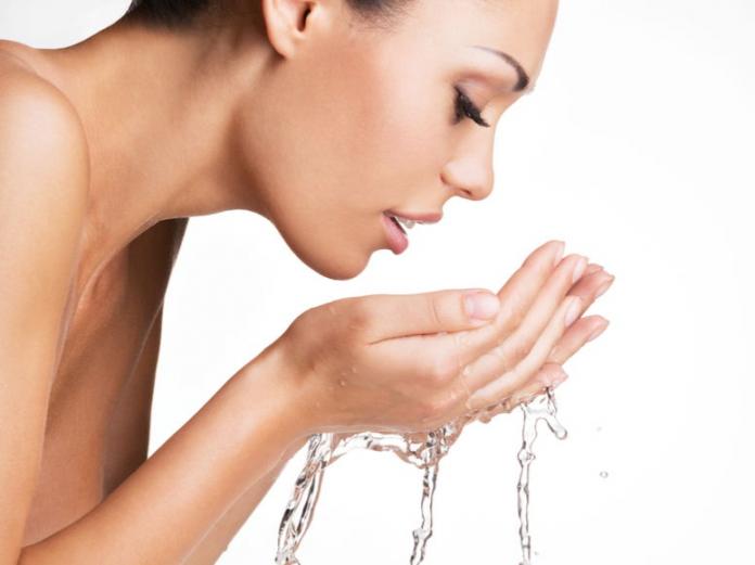 mujer lavándose la cara