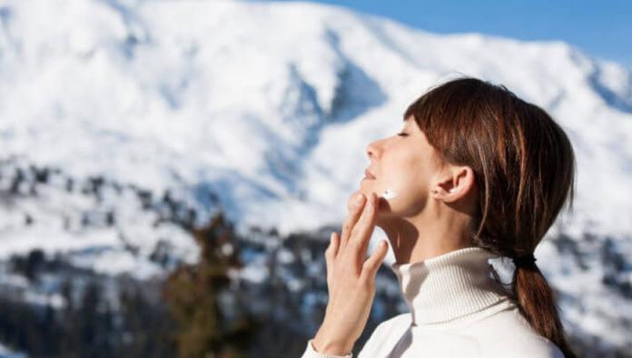 Mujer poniéndose crema en invierno