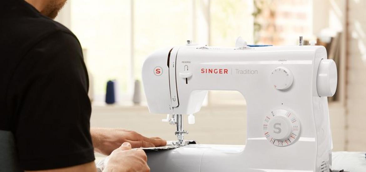 Hombre cosiendo con la máquina Singer de Lidl