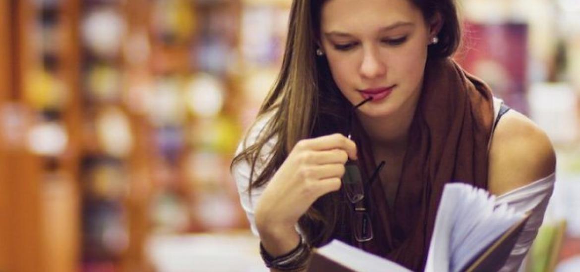 Mujer leyendo en una biblioteca