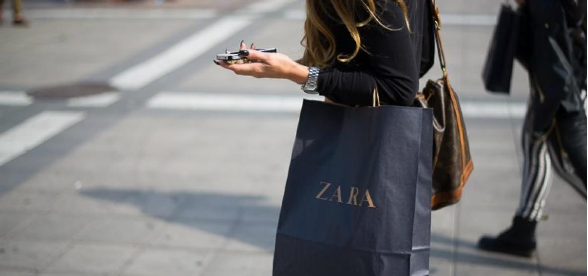Mujer paseando con una bolsa de Zara