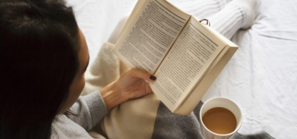 Mujer leyendo un libro en la cama