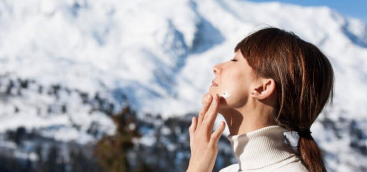 Mujer poniéndose crema en invierno