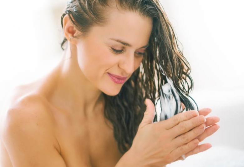 Mujer aplicándose mascarilla en el cabello