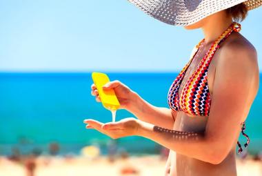 Mujer aplicándose crema solar