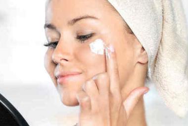 Mujer aplicándose crema facial