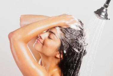 Mujer lavándose el pelo en la ducha